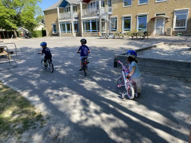 Børn cykler på legepladsen 